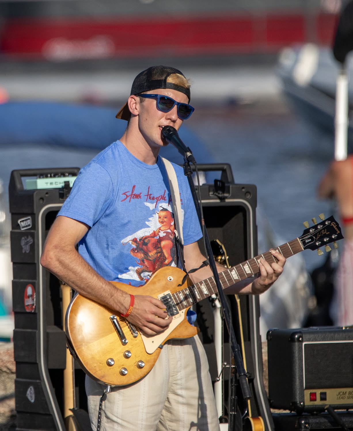 Ryan North performing with electric guitar at an outdoor lakeside show